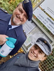 Auf dem Bild sieht man zwei Personen; von dem einer eine Sammeldose in der Hand hält