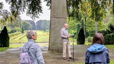 Auf dem Bild sieht man Bürgermeister Heinen vor einem überlebensgroßen Steinkreuz eine Rede haltend.