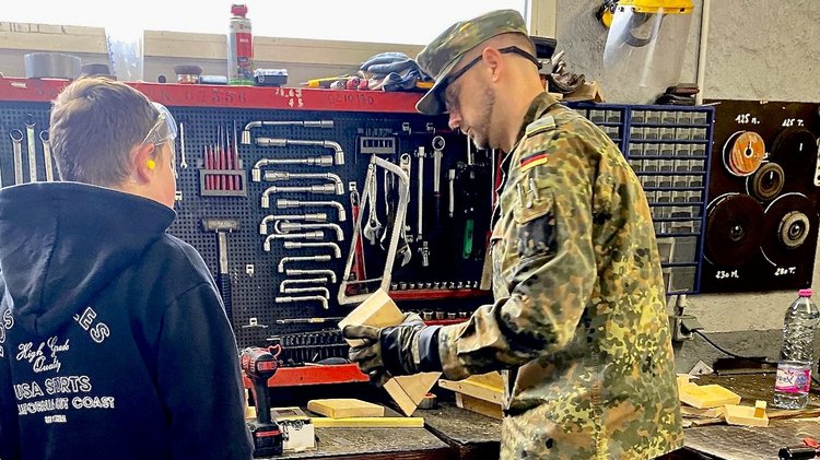 Schüler und Soldat bauen ein Vogelhäuschen